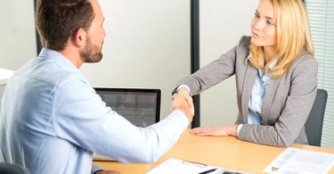 man and women in job interview shaking hands