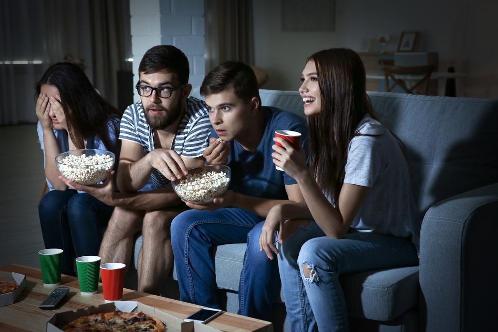 group of college students watching movie in the dark