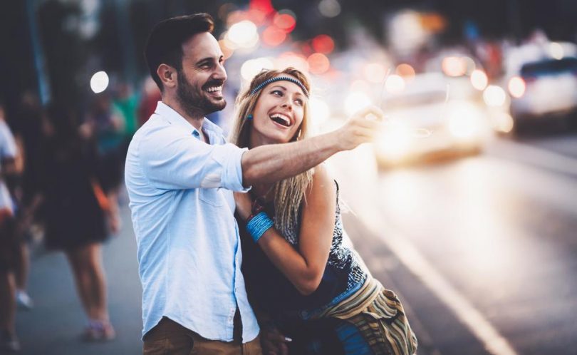 male and female college students out on a date smiling in the street