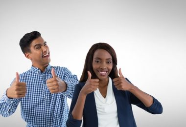 College Male and femal student giving a thumbs up in front of a white background