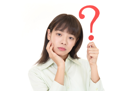 female Asian college student holding up a question mark symbol on white background