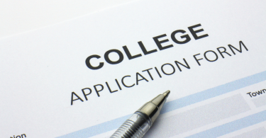 college application form with a pen sitting on top of it