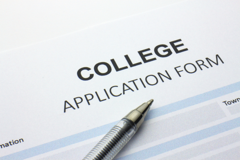 college application form with a pen sitting on top of it