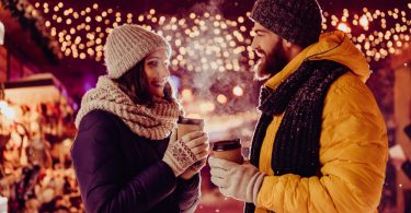 couple on date outside in the winter holding hot drinks