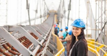 smiling female in blue hard hat working on site