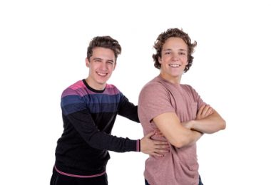 two male college roommates smiling on white background