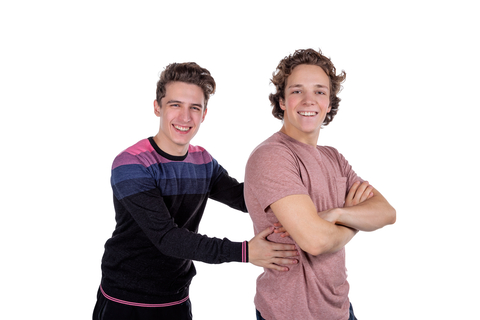 two male college roommates smiling on white background