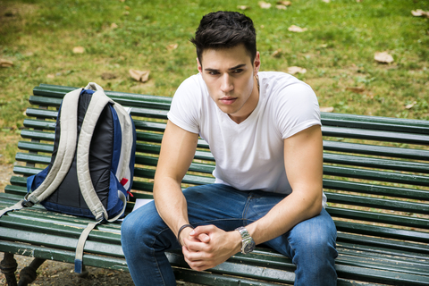 male student sitting on bench after being rejected by college admissions